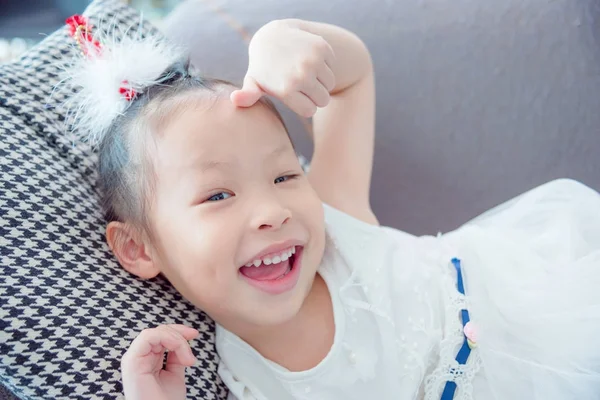 Little girl wearing white color dress lying and smi — Stock Photo, Image