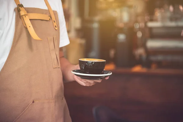 Main de serveur servant une tasse de café dans un café — Photo