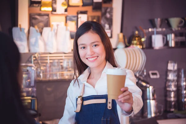 Belle barista donnant tasse de café à son client et sourire — Photo