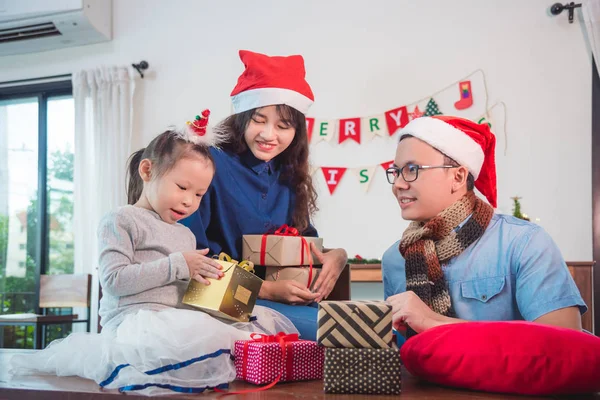 Klein meisje en haar ouders open kerst geschenkdozen — Stockfoto