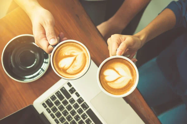 Hands holding coffee cup on working desk with laptop — Stock Photo, Image