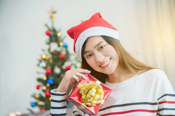 Mooie vrouw dragen Kerstman hoed en houden de doos van de gift — Stockfoto