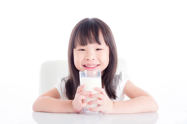 Niña sentada y sosteniendo un vaso de leche sobre blanco —  Fotos de Stock