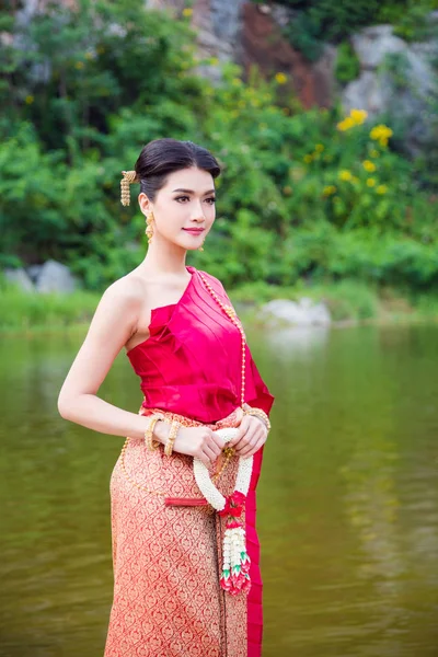 Vrouw dragen van Thaise traditionele kleding bedrijf bloem in de buurt van de rivier — Stockfoto
