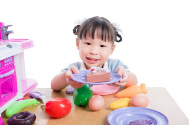 Küçük kız üzerinde beyaz mutfak oyuncakla oynamak 