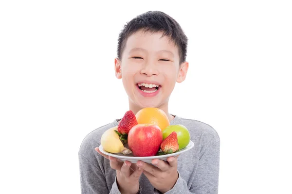 Boy holding fruits and smiles over white background — Stock Photo, Image