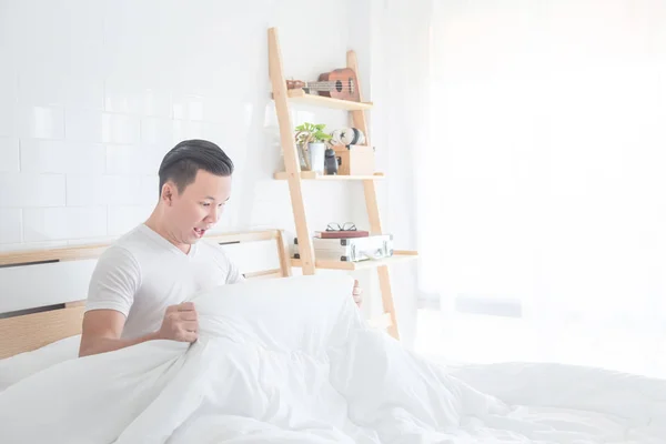 man looking under blanket with excited face