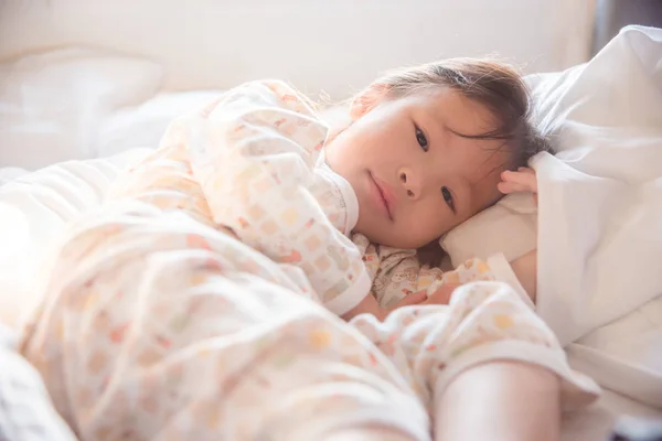 Meisje op bed in de vroege ochtend wakker — Stockfoto