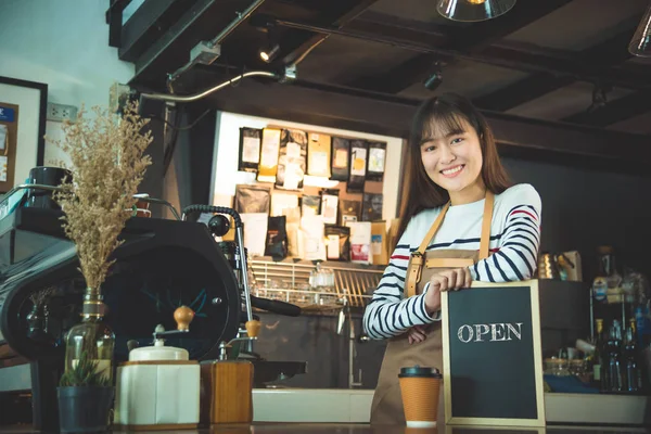 Barista tenant tableau noir avec mot "ouvert" " — Photo