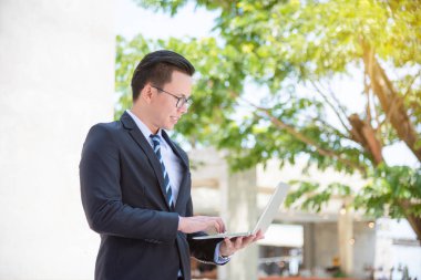 Dizüstü bilgisayar açık kullanan takım elbise genç Asya iş adamı
