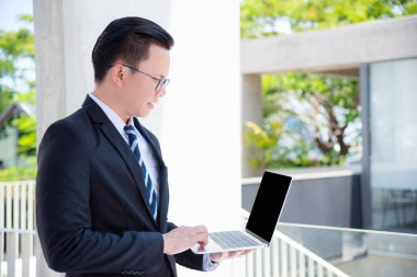 Dizüstü bilgisayar açık kullanan takım elbise genç Asya iş adamı