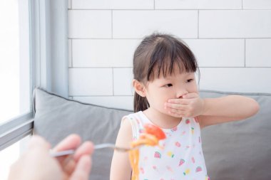 Küçük Asyalı kız kapat ağzını elle domates yemek reddediyorum 