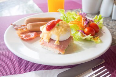 Yumurta benedict, jambon, sosis ve salata 