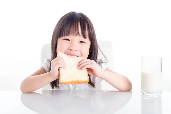 Piccola Ragazza Asiatica Mangiare Pane Con Bicchiere Latte Prima Colazione — Foto Stock