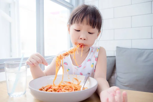 Ragazza mangiare spaghetti da sola con bocca sporca al ristorante — Foto Stock