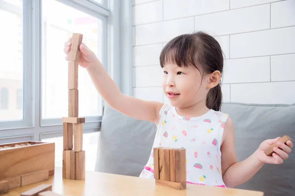 Chica jugando bloques de madera en casa — Foto de Stock