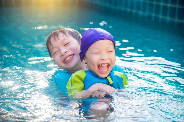 Anak-anak dengan baju renang bermain di kolam renang — Stok Foto