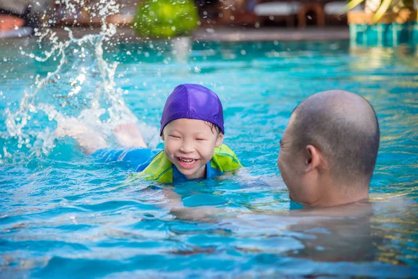 Flicka lära sig simma med sin far i poolen — Stockfoto
