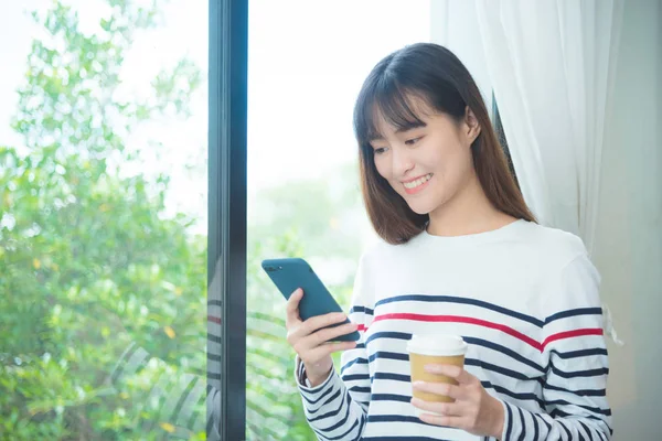 Frau liest Nachricht auf Handy und lächelt — Stockfoto