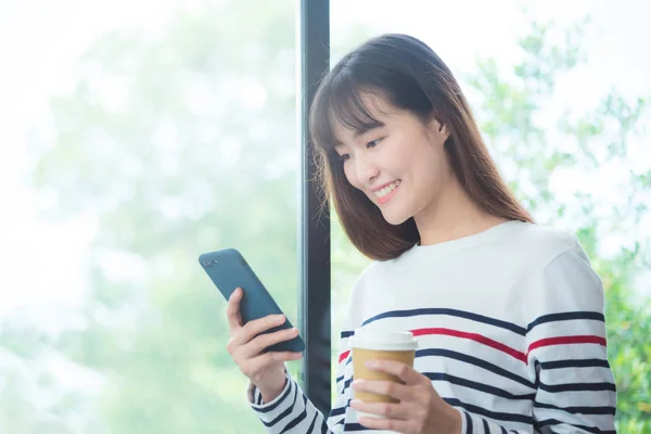 Frau liest Nachricht auf Handy und lächelt — Stockfoto