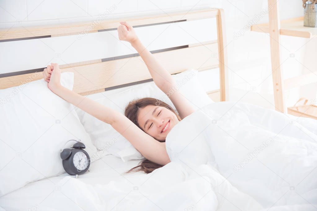 woman stretching on bed in the morning
