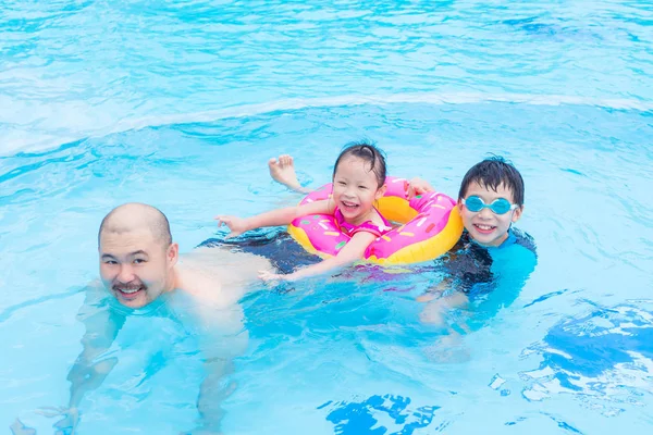 Glad familj leker i poolen — Stockfoto