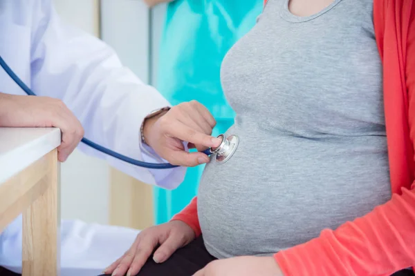 Medico che controlla la donna incinta mediante stetoscopio — Foto Stock