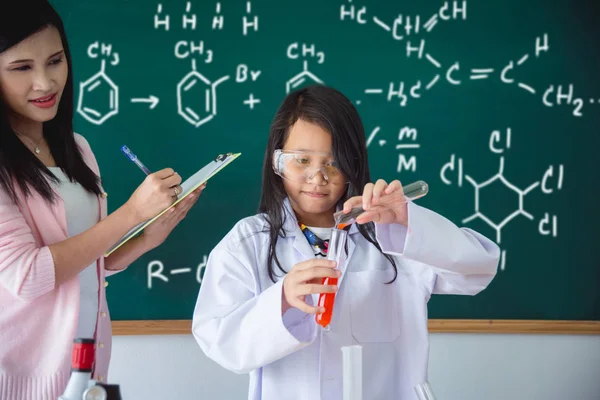 Genç Asyalı Kız Öğrenci Sınıfta Kimyasal Sıvı Dökme — Stok fotoğraf