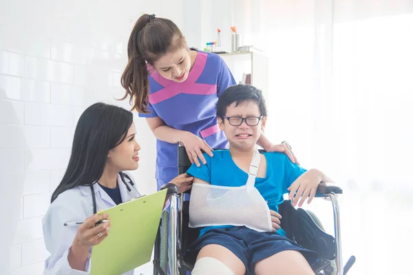 Mooie arts en verpleegkundige verzorgen jongen patiënt — Stockfoto