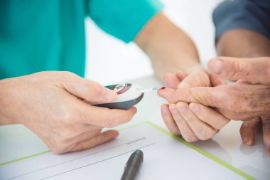 Hemşirenin kullanarak şeker ölçüm üzerinde hastanın parmak eller