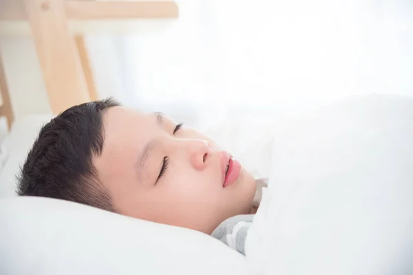 Primer plano chico durmiendo en la cama en la mañana — Foto de Stock