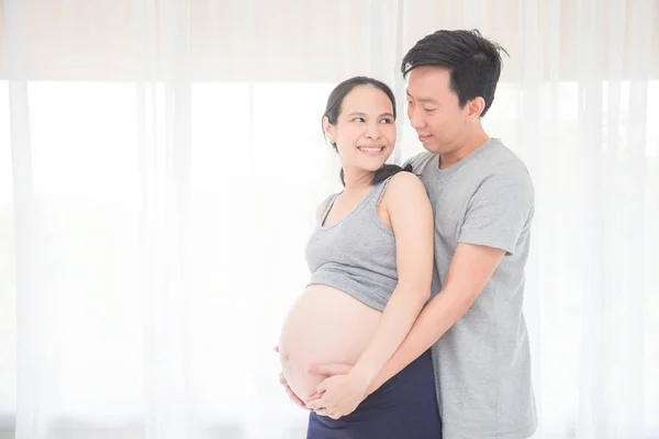 Pregnancy smiles with her husband at home — 图库照片
