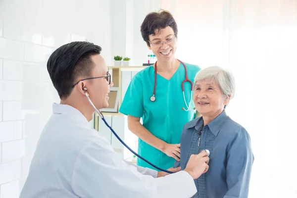 Dokter van controle patiënt hartslag door stethoscoop in ziekenhuis — Stockfoto