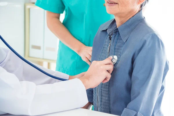 Médico revisando el latido del corazón del paciente por estetoscopio —  Fotos de Stock