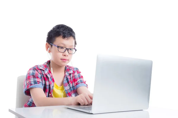 Niño joven con auriculares y el uso de ordenador portátil —  Fotos de Stock