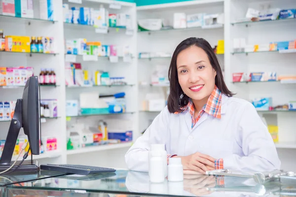 Krásný lékárník stojí v lékárně a usmívá se — Stock fotografie