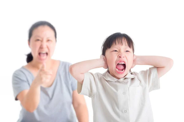 Menina descontente cobrindo seus ouvidos de repreendido por sua mãe e gritando — Fotografia de Stock