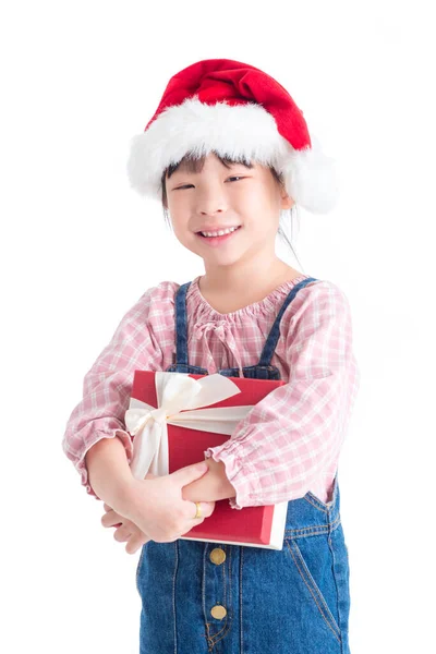 Klein meisje draagt kerstman hoed met geschenkdoos en glimlacht — Stockfoto