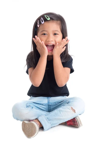 Volle Länge des kleinen Mädchens sitzt und lächelt isoliert über weiß — Stockfoto