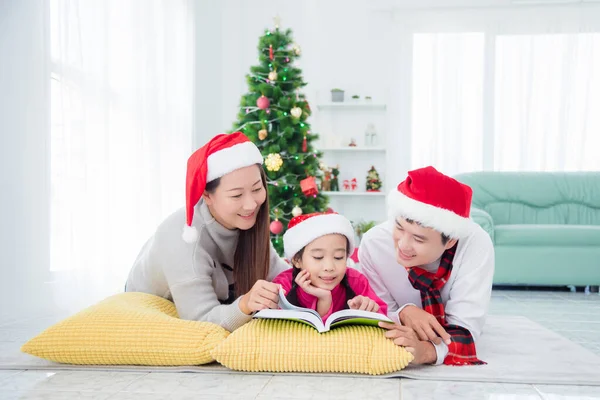 Gelukkig aziatische familie liggend op de vloer en het lezen van boek samen — Stockfoto