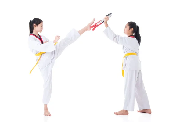 Two young asian girls having taekwondo training ,one girl kicking while other one girl holding kick target — Stock Photo, Image