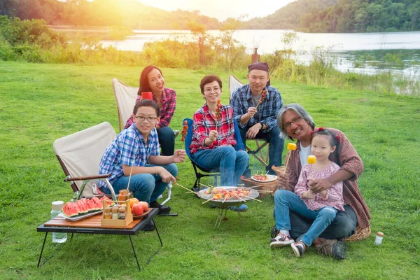 Happy asian family camping and enjoy with Bar-B-Q together
