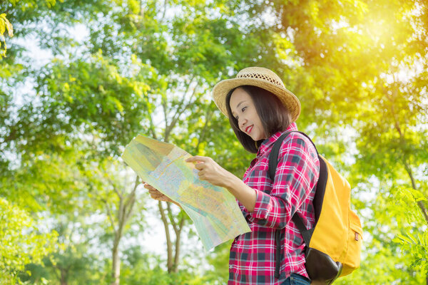 Asian traveler woman with backpack walking in the tropical forest.