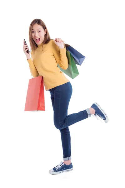 Volledige lengte van Mooie Aziatische vrouw met veel boodschappentassen en mobiele telefoon met verrassingsgezicht — Stockfoto