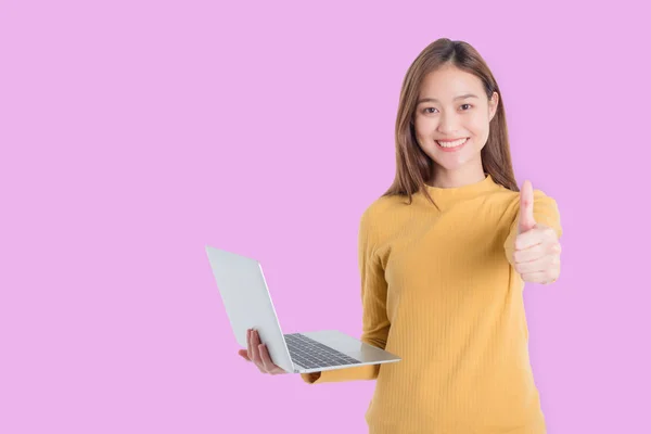 漂亮的年轻亚洲女人拿着笔记本电脑，微笑着竖起大拇指 — 图库照片