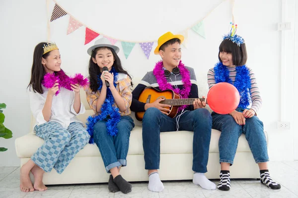 Groep gelukkig tiener zingen een lied en spelen gitaar met vrienden in partij. — Stockfoto