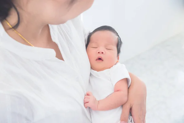 Asiática mãe segurando seu bebê recém-nascido em casa — Fotografia de Stock