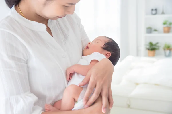 Asijské matka holding ji málo novorozenec dítě doma — Stock fotografie