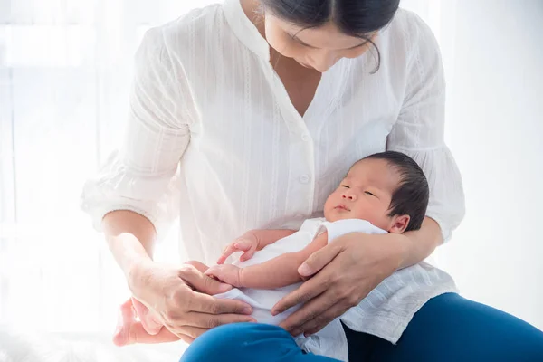 Азиатская мать держит своего новорожденного ребенка дома — стоковое фото