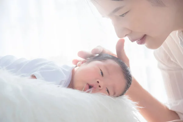 Asiatisk mor rör vid sitt nyfödda barn med kärlek på morgonen — Stockfoto